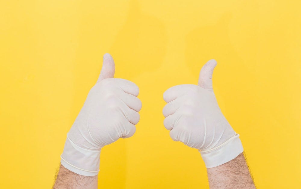 person in white long sleeve shirt doing thumbs up sign